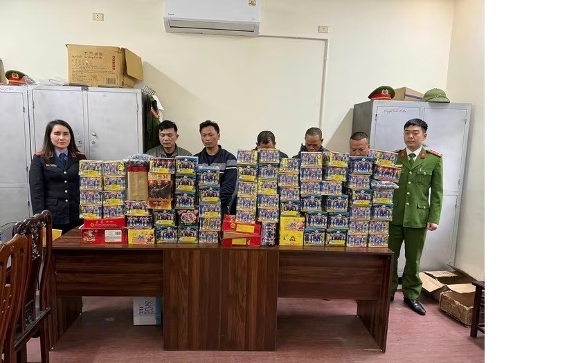 Các đối tượng (đứng giữa) cùng tang vật tại cơ quan Công an. Ảnh CANA