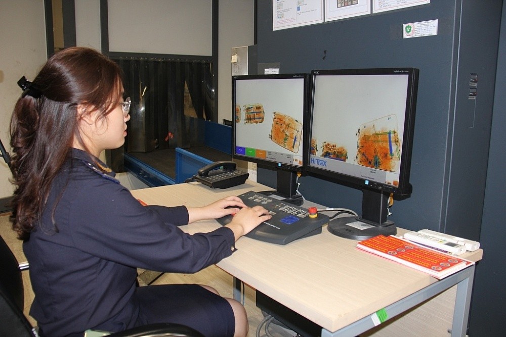 Công chức Hải quan khu vực XIII kiểm tra hành lý qua máy soi. Ảnh: T.H