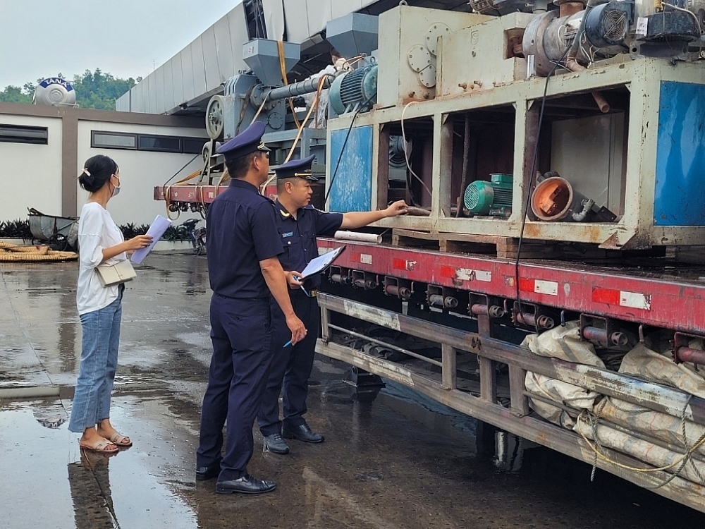 Công chức hải quan kiểm tra máy móc nhập khẩu. Ảnh: H.Nụ