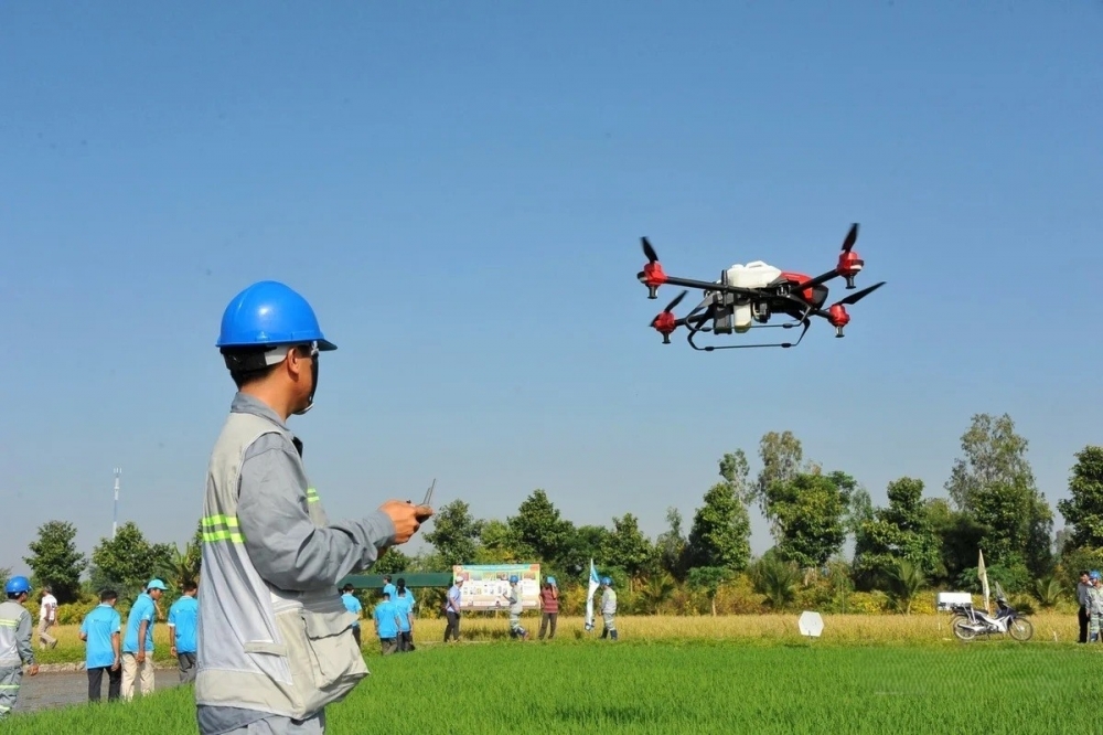 Ứng dụng drone trong sản xuất lúa tại An Giang giúp gieo sạ, bón phân và phun thuốc chính xác, tiết kiệm chi phí, giảm lao động thủ công và hạn chế tác động tiêu cực đến môi trường. Ảnh: Lê Hoàng Vũ.