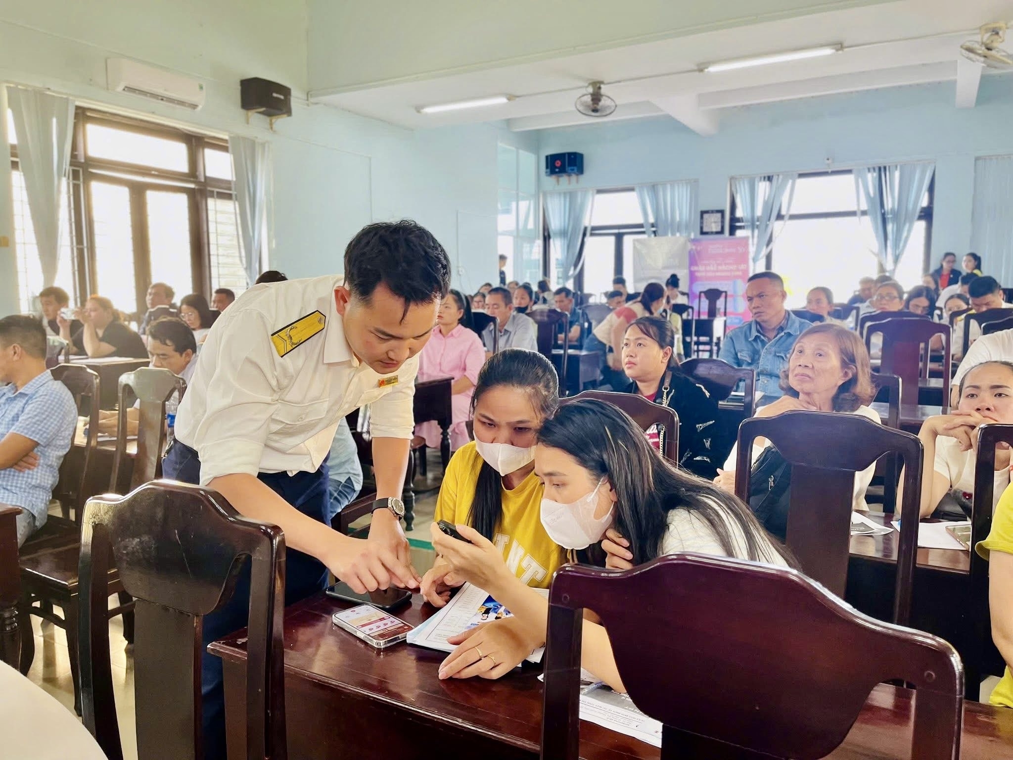 Công chức thuế cơ sở 2 thành phố Huế hỗ trợ hộ kinh doanh cài đặt ứng dụng eTax Mobile. Ảnh: TCS2.
