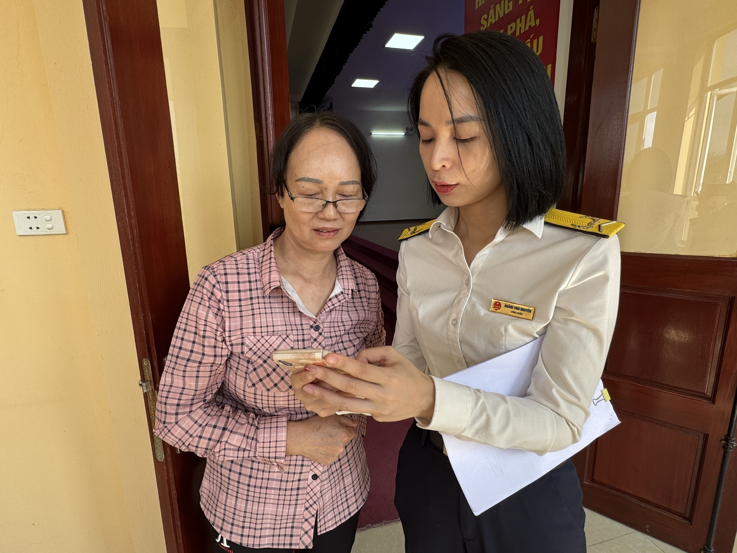 Công chức thuế cơ sở 5 tỉnh Lạng Sơn hỗ trợ hộ kinh doanh cài đặt ứng dụng eTax Mobile. Ảnh: HQ.