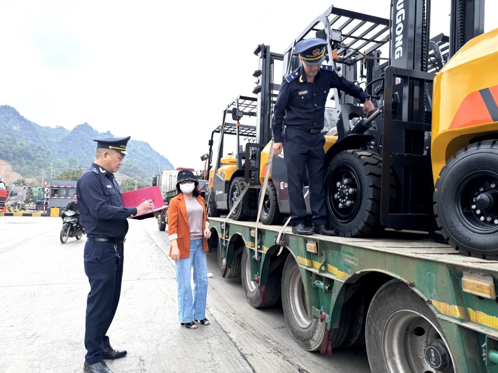 Công chức Hải quan khu vực VI phối hợp với đại diện doanh nghiệp kiểm tra hàng máy móc nhập khẩu. Ảnh: H.Nụ
