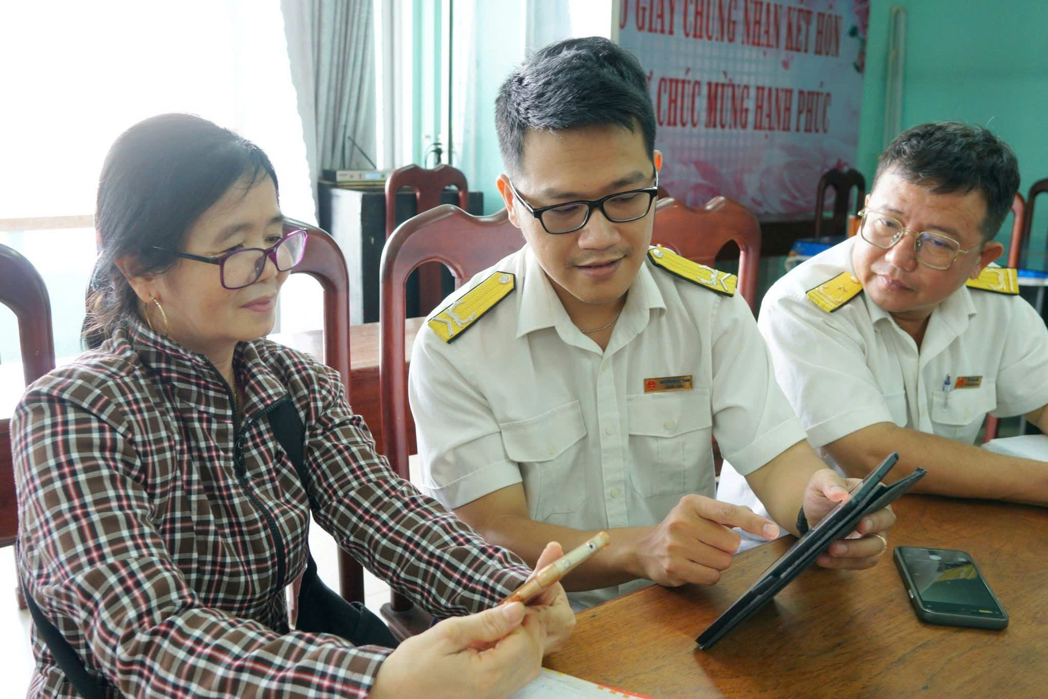 Công chức Thuế cơ sở 1 tỉnh Gia Lai hướng dẫn người nộp thuế cài đặt eTax Mobilie. Ảnh: Thuế cơ sở 1 tỉnh Gia Lai.