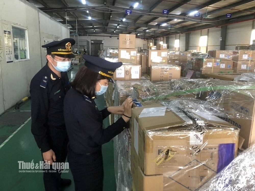 Công chức hải quan kiểm tra hàng hóa tại kho của doanh nghiệp chế xuất. Ảnh: H.Nụ
