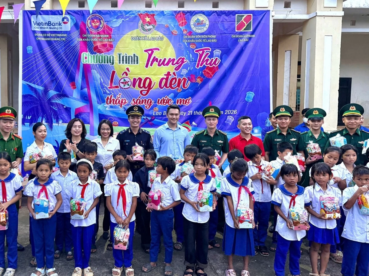 Đại diện Chi đoàn Hải quan cửa khẩu quốc tế Lao Bảo trao quà và chụp ảnh lưu niệm với các em nhỏ. Ảnh: Chi cục HQKV IX