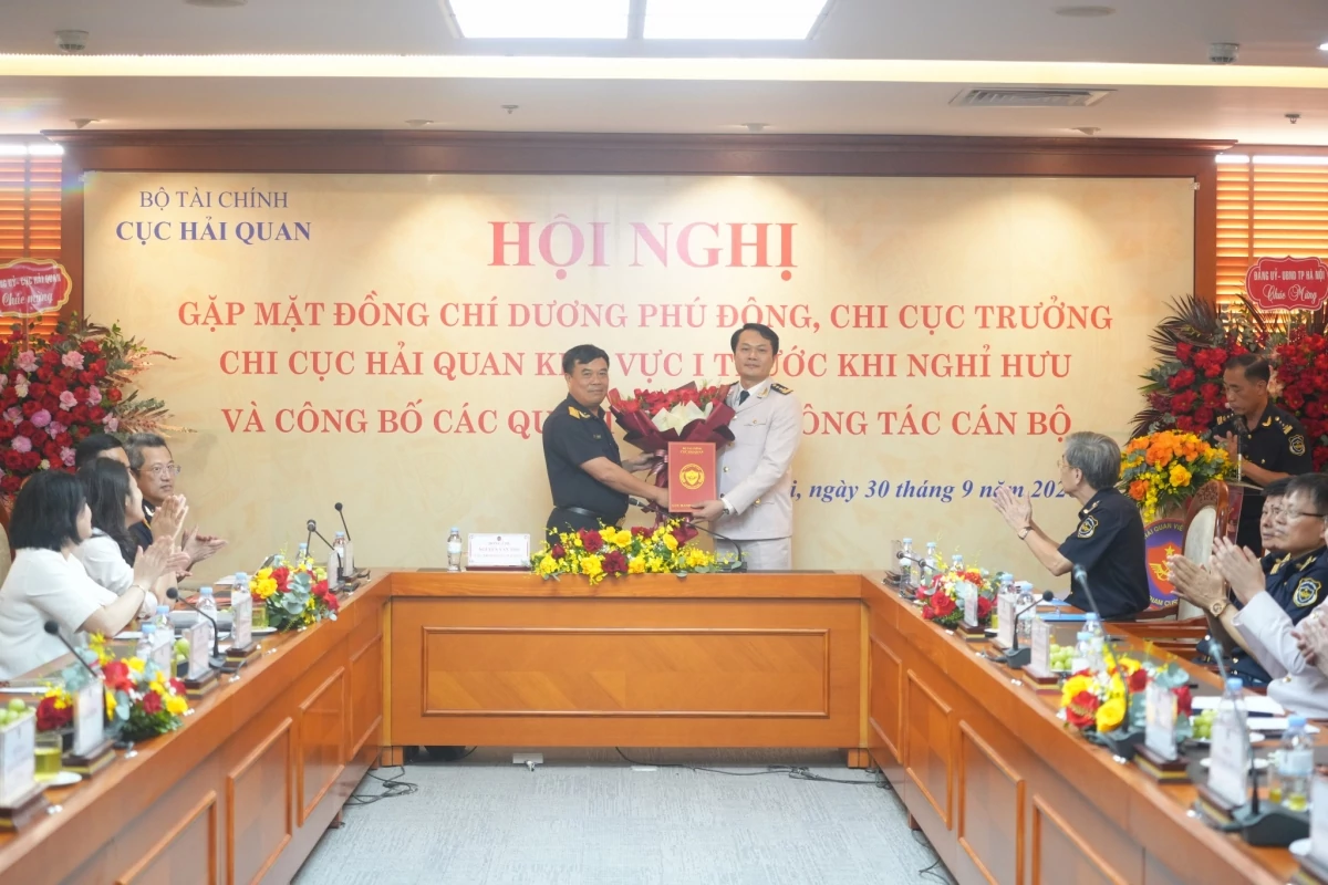 Cục trưởng Cục Hải quan Nguyễn Văn Thọ (bên trái) trao quyết định và tặng hoa chúc mừng ông Hoàng Quốc Quang, Chi cục trưởng Chi cục Hải quan khu vực I. 