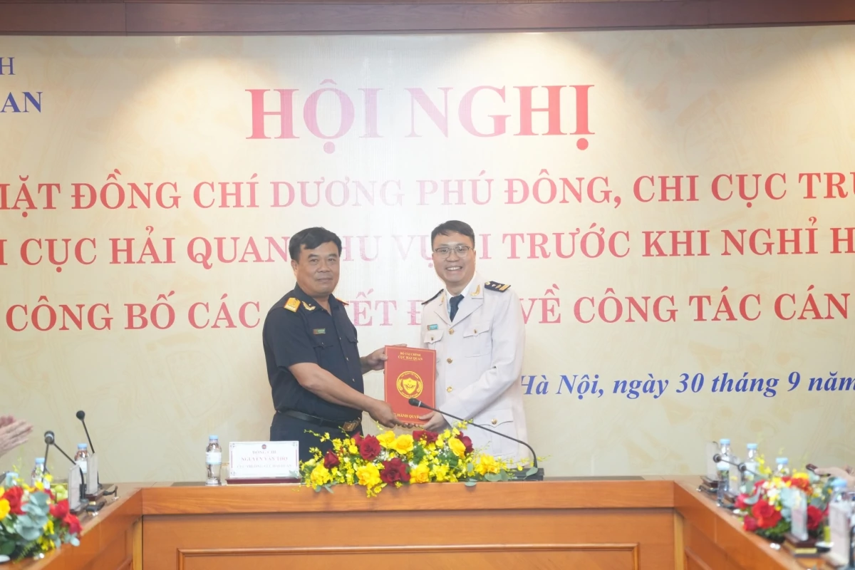 Cục trưởng Cục Hải quan Nguyễn Văn Thọ (bên trái) trao quyết định và tặng hoa chúc mừng ông Đỗ Hoàng Anh Khoa, Phó Chi cục trưởng Chi cục Hải quan khu vực I.