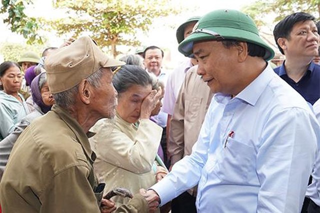 Thủ tướng Nguyễn Xuân Phúc thăm hỏi, động viên người dân bị thiệt hại do mưa lũ tại huyện Quảng Ninh, tỉnh Quảng Bình. Ảnh: VGP/Quang Hiếu