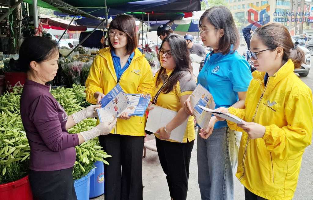 Cán bộ BHXH tuyên truyền vận động tiểu thương tham gia BHXH tự nguyện.