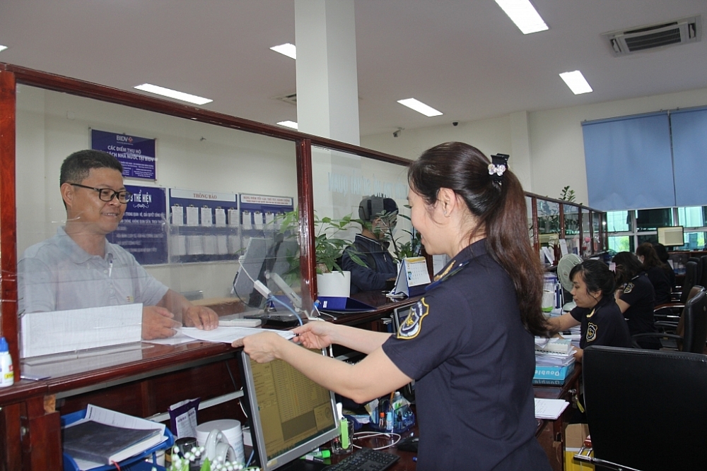 Công chức Hải quan Sóng Thần, Cục Hải quan Bình Dương hướng dẫn thủ tục hải quan cho doanh nghiệp.  Ảnh: T.D